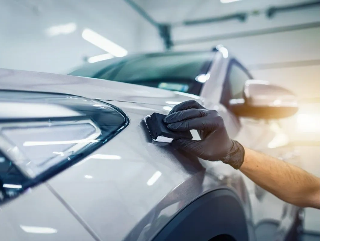 Ceramic coating being applied by hand to the panel of a silver vehicle